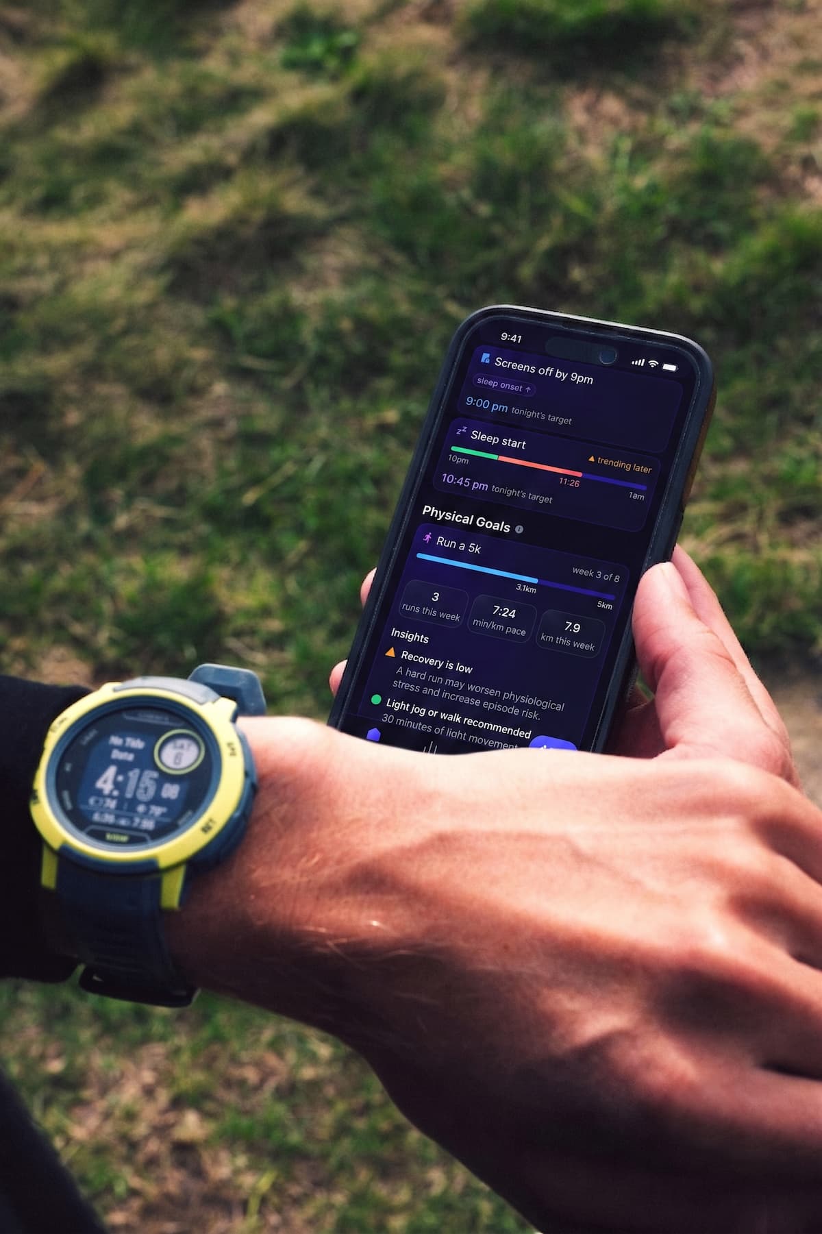 A man bending over to tie his orange running shoes. A Garmin watch is featured prominently on his left hand.